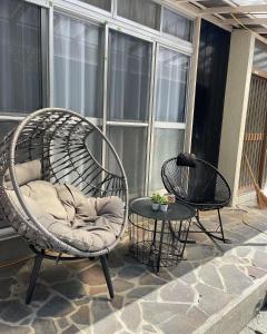 a swing chair on a patio with two tables at FRIENDS in Futae