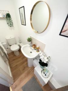 a bathroom with a sink and a toilet and a mirror at Lovely 1 Bedroom Flat In Gravesend in Kent