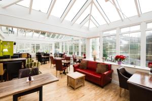 a restaurant with a red couch and tables and chairs at Killin Hotel in Killin