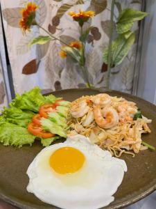 a plate of food with shrimp and eggs on a plate at Angkor Piseth Homestay in Siem Reap