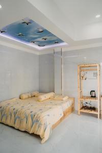 a bedroom with a bed with a blue ceiling at Home Sweet Home in Tây Ninh