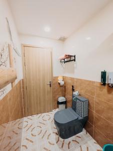 a bathroom with a toilet and a wooden door at Home Sweet Home in Tây Ninh