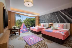 1 dormitorio con 2 camas, escritorio y ventana en Xiamen C&D Hotel-Free Welcome Snacks-Oasis Garden, en Xiamen