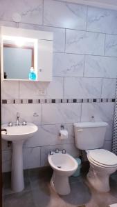 a white bathroom with a toilet and a sink at Lajas Del Sur in Ushuaia