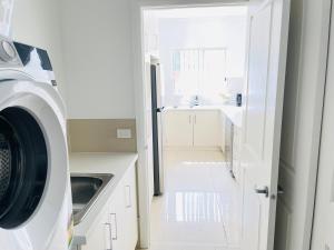 uma cozinha com uma máquina de lavar roupa e um lavatório em Modern City Townhouse with all the Comforts em Wagga Wagga