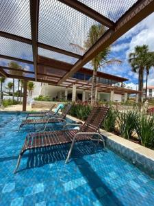 3 sillas sentadas en una piscina con una valla en Suites Quinta Santa Barbara en Pirenópolis