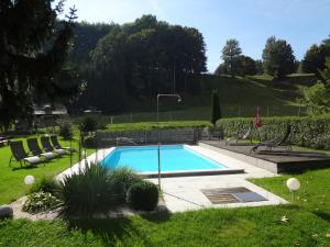 a swimming pool in a yard with chairs around it at Gasthofladen Schneeweiss in Attersee am Attersee