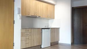 a kitchen with a white refrigerator and wooden cabinets at Apartamentos Turísticos Teruel in Teruel