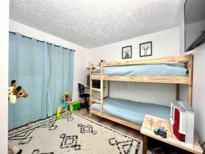 a bedroom with two bunk beds and a television at Pocono Mountain Dream House near Camelback in Tobyhanna