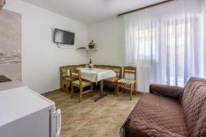 a living room with a table and a couch at Apartment Kreso in Punat