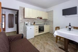 a kitchen with a couch and a table in a room at Apartment Kreso in Punat