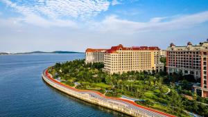 una vista aerea di un resort su un corpo idrico di Crowne Plaza QingdaoOrientalMovieMetropolis, an IHG Hotel a Huangdao
