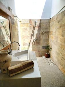 Baño con lavabo y jarrón en Amel House, en Gili Air