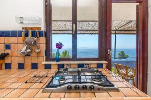 a kitchen with a stove top in a kitchen with windows at Apartments Ana in Blato