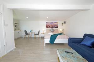 a bedroom with a bed and a couch and a table at Beachside Compact Backyard Cabin near Mentone in Parkdale