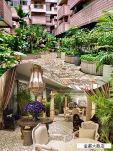 un vestíbulo con muchas plantas y muebles en Chihpen Hotel Royal Kingdom, en Wenquan