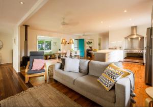 a living room with a couch and a kitchen at Sea Dip at Iluka in Iluka