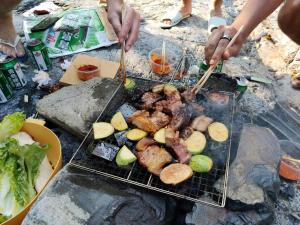 a person cooking meat and vegetables on a grill at 昭希舍 Banji Arbre House, a traditional lodge home on rice terrace in Liping