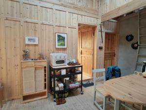 um quarto com paredes de madeira, uma mesa e um micro-ondas em 昭希舍 Banji Arbre House, a traditional lodge home on rice terrace em Liping