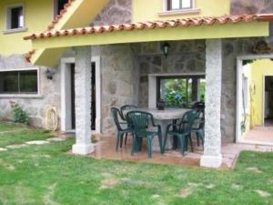 a patio with a table and chairs on a house at House - 3 Bedrooms with WiFi - 00075 in Bueu