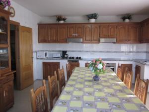 una cocina con una mesa con un jarrón de flores. en House - 5 Bedrooms - 00174, en Cacabelos