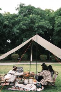 a group of people sitting at a table under a tent at Xiamen C&D Hotel-Free Welcome Snacks-Oasis Garden in Xiamen