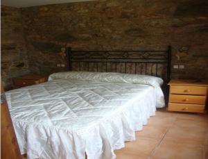 a bedroom with a white bed and a stone wall at House - 2 Bedrooms - 03474 in Viseo