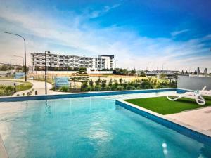 a swimming pool with a building in the background at Pool, 100m to Hosp, 3 TVs, 3 Beds - Lakefront Aquarius Apartment in Kawana Waters