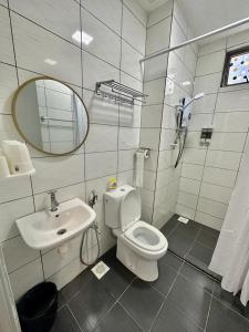 La salle de bains est pourvue de toilettes, d'un lavabo et d'un miroir. dans l'établissement Kensington Sunrise at Sg Palas,PalasHorizon, à Tanah Rata