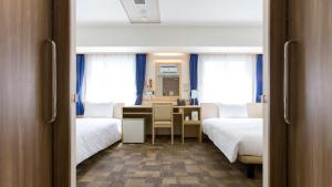 a hotel room with two beds and a desk with a desk at Toyoko Inn Shizuoka eki Minami guchi in Shizuoka