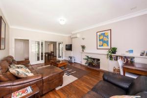 ein Wohnzimmer mit Sofa und Tisch in der Unterkunft Busselton River Cottage with WiFi in Busselton