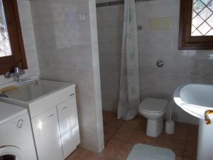 a bathroom with a white sink and a toilet at Villa Venturelli in Tignale +4 photos
