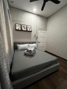 une chambre avec un lit avec un ventilateur de plafond dans l'établissement BELLA COTTAGE, à Pantai Cenang