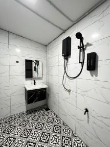 een badkamer met een douche, een wastafel en een spiegel bij BELLA COTTAGE in Pantai Cenang