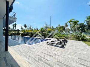 a swimming pool with benches next to a resort at Roxy Sematan Beach Townhouse Deluxe 7 ,8 ,9 in Sematan