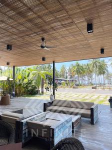 un patio con bancos y techo de madera en Roxy Sematan Beach Townhouse Deluxe 7 ,8 ,9 en Sematan
