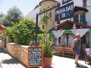a man standing in front of a restaurant with a sign at Pasha Apart Hotel in Kalkan