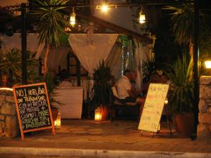 um grupo de pessoas sentadas num restaurante à noite em Pasha Apart Hotel em Kalkan