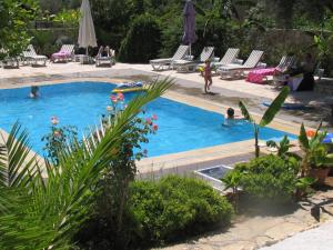 a pool with people swimming in it with lounge chairs at Pasha Apart Hotel in Kalkan