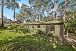 a small house in the middle of a yard at 37 Coastal Court Bush Retreat By the Sea in Dalmeny