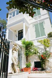 a white house with a statue in front of it at Emeraude Résidence Hotelière in Juan-les-Pins