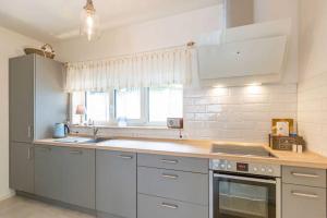 een keuken met witte kasten en een fornuis met oven bij Gartenhaus am Waldschloss App 1 in Heringsdorf
