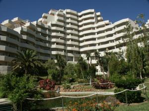 ベナルマデナにあるApartamentos Benal Beach - Geinsaの白い大きな建物(正面に庭園あり)
