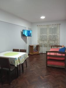 sala de estar con mesa, sillas y TV en Nebur en Mendoza
