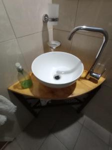 lavabo blanco en un soporte de madera en el baño en Nebur en Mendoza