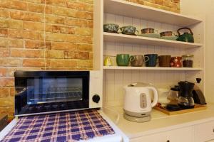 a kitchen with a brick wall and an oven at EK House Kamakura 鎌倉 Free Parking in Kamakura