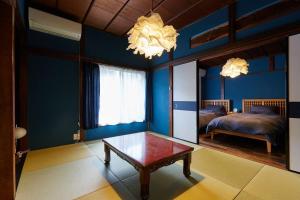 a bedroom with blue walls and a table and a bed at EK House Kamakura 鎌倉 Free Parking in Kamakura