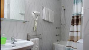 a bathroom with a sink and a phone on the wall at Hostal Cervantes in Madrid