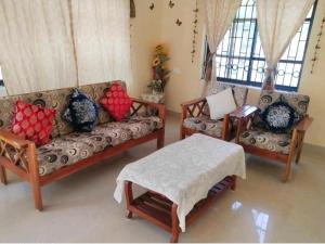 sala de estar con sofá y 2 sillas en HIS GRACE BEACH VILLA - Near MALPE BEACH, en Udupi