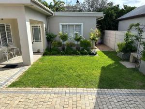 a house with a yard with green grass at Melkbos Holiday Accommodation in Melkbosstrand